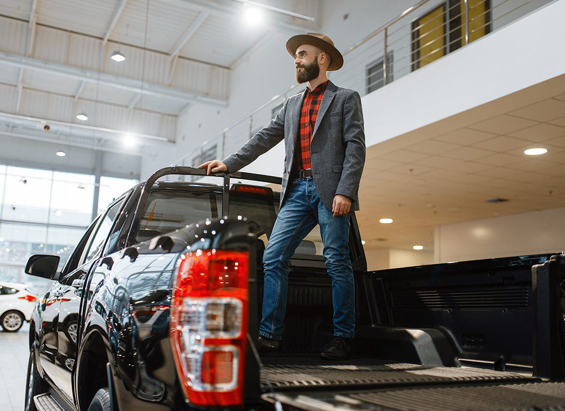 Business Insurance - Man Standing in the Back of New Pickup Truck at a Dealership